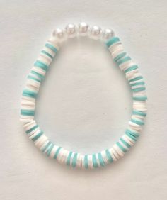 This teal and white stretch bracelet with pearls fits up to a 6.5" wrist. A great gift for a special girl! All jewelry is made with care by my 11 year old granddaughter. She's quite the entrepreneur and loves earning her own spending money. Clay Bead Necklaces Ideas, Teal Clay Bead Bracelet, Clay Bead Brackets Ideas, Clay Bead Bracket Idea, Clay Bead Bracelet Inspo Aesthetic, Pearl Clay Bead Bracelet Ideas, Trendy Clay Bead Bracelets, Adjustable Hypoallergenic White Pearl Bracelet, Playful White Heishi Beads Stretch Bracelet