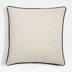 a white pillow with black piping on the front and back, against a white background