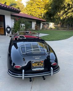 a black sports car parked in front of a house