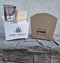 an open camp jar with cookies and marshmallows in it sitting on a wooden table