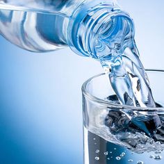 water pouring into a glass filled with rocks and ice cubes in front of a blue background that says consumption of water so you are fully hydrated can increase your metallic rate