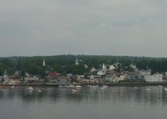 boats are floating on the water in front of houses