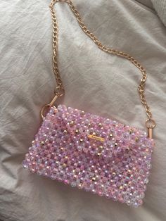 This elegant, handmade beaded handbag in delicate shades of pink, purple and white is a real eye-catcher. The shimmering beads and gold details give the bag a luxurious touch, while at the same time it is practical enough to hold all your essentials. Characteristics - High-quality handmade beadwork - Colors: pink, purple, white with glittery accents and gold details - Secure magnetic closure - Offers space for the most important items such as cell phone, keys and lipstick Care instructions - Wip Pink Handheld Evening Bag For Mobile Phone, Pink Sequin Evening Bag, Pink Rectangular Beaded Clutch, Rectangular Pink Beaded Clutch, Pink Rectangular Clutch With Rhinestones, Pink Beaded Rectangular Clutch, Everyday Pink Beaded Bag, Glamorous Pink Embellished Shoulder Bag, Pink Rhinestone Clutch Evening Bag