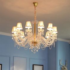 a chandelier hanging from the ceiling in a room with blue walls and white trim