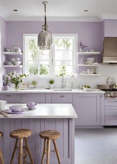 a kitchen with purple walls and wooden stools