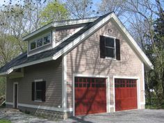 a two car garage with three windows on the top floor and an attached loft above it