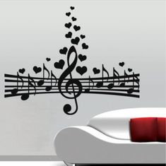 a couch sitting next to a wall with musical notes and hearts on it's side