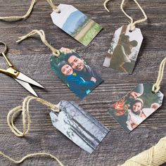 four different pictures hanging from twine on a wooden table next to yarn and scissors