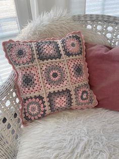 a crocheted pillow sitting on top of a white chair