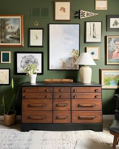 a dresser with many pictures on the wall