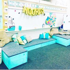 an empty classroom with blue couches and pillows