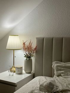 a bedroom with a bed, nightstand and lamp