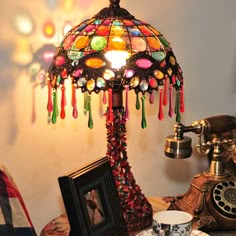 a lamp that is on top of a table next to a cup and saucer