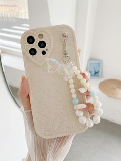 a person holding up a phone case with beads