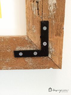 a wooden frame with two black brackets on it