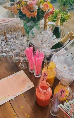 there are many glasses and bottles on the table with straws in them, including orange juice