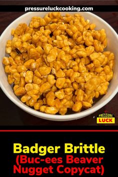 a white bowl filled with buttered peanuts on top of a wooden table next to a red and black sign