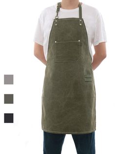 a man standing with his hands in his pockets and wearing an olive green canvas apron