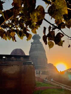 the sun is setting over an old building with stairs leading up to it's top