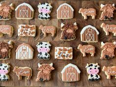 decorated cookies with farm animals and horses are on a wooden table next to each other