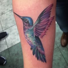 a colorful hummingbird tattoo on the leg