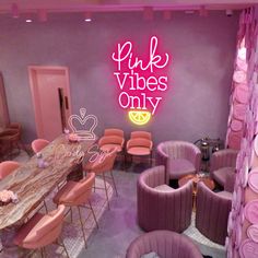 pink chairs and tables in a room with purple walls