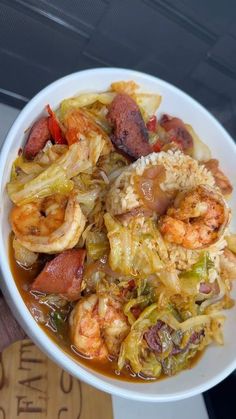 a white bowl filled with lots of food on top of a table