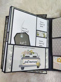 the inside of a handmade wedding album with cards and tags on it, sitting on a white furnishing