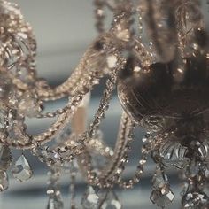 a chandelier hanging from the ceiling with lots of crystal beads on it's arms