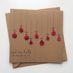 three brown cards with red buttons attached to them and the words deck the hall written in black