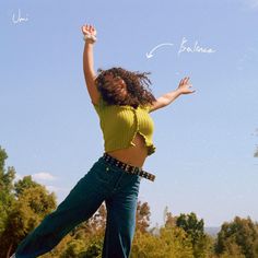 a woman jumping in the air with her arms outstretched