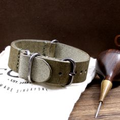 "At Cozy Handmade, we pride ourselves on using the highest quality materials for our products. This 4-Ring style watch strap is made of premium full grain Italian veg tanned leather from one of the best tanneries in Italy. The leather comes with gorgeous textures with unique rustic appearance. Its appearance will get even better with time as it acquires patina, wrinkles and marks. This watch strap comes with an extra under strap. It is stitched with green color thread. Available in 4 sizes and 6 Adjustable Vegetable Tanned Leather Watch Bands With Waxed Finish, Leather Watch Bands For Outdoor, Adjustable Leather Watch Bands For Outdoor, Outdoor Leather Strap Watch Band, Adjustable Leather Strap Watch Band For Outdoor, Veg Tan Leather, Style Watch, Chocolate Color, Leather Watch Strap