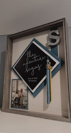 a graduation cap and tassel hanging on a wall with the letter s in it