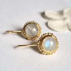 Antique style solid gold drop round moonstone earrings, feminine romantic jewelry, bridal earrings for women, available in 9k or 14k yellow gold. Delicate handmade round gold earrings set with light rainbow moonstone gems and embellished with delicate granules, adding an antique touch to their style. They are available in 9k or 14k yellow gold. The earrings are delicate and romantic, making them highly suitable for a bride. They are perfect for adding a touch of glamour to any outfit and will st Hand Forged Wedding Earrings, Elegant Yellow Gold Moonstone Earrings, Gold Hand-forged Moonstone Earrings, Gold Hand Forged Moonstone Earrings, Gold Moonstone Hand Forged Earrings, Handmade Yellow Gold Moonstone Earrings, Moonstone Round Yellow Gold Earrings, Delicate Round Moonstone Earrings, Hand Forged Gold Moonstone Earrings