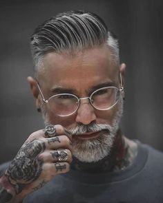 a man with tattoos and glasses on his face