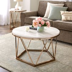 a living room table with flowers on it in front of a couch and coffee table