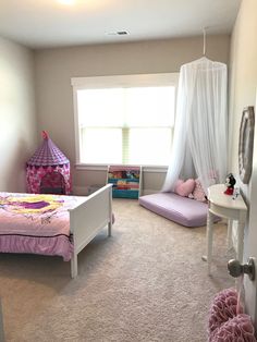 a child's bedroom decorated in pink and purple