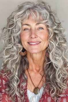 Voluminous, romantic, and enticing, this layered curls with side-swept fringe hairstyle does not disappoint. While it looks complex and challenging to maintain, it couldn’t be easier.  Click here to check out more best long hairstyles for women over 60. Long Curly Gray Hair, Long Curly Hair With Fringe, Permed Hairstyles Long, Curly Long Hair With Bangs, Over 60 Long Hairstyles, Curly Grey Hair Natural Curls, How To Curl Long Hair, Big Fluffy Hair, Makeup For Gray Hair