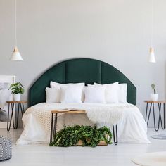 a green headboard on a bed with white sheets and pillows in a modern bedroom