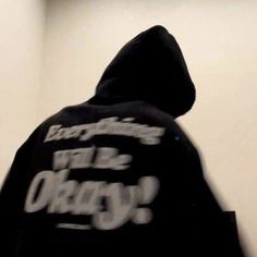 a person wearing a black hoodie with white writing on it