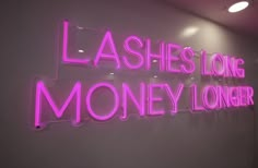 a neon sign that says lashes long money longer on the wall in front of a white wall