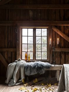 a room with wooden walls and flooring has a bench in front of the window