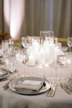 the table is set with silverware and candles for an elegant wedding reception or special event