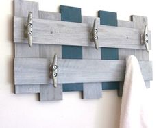 a towel is hanging on a wall with hooks and pegs attached to the board