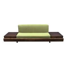 a green couch sitting on top of a wooden table