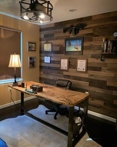 an office with wood paneling and a desk in front of a window that has a lamp on it