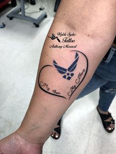 a person with a tattoo on their arm that has an eagle and heart in it