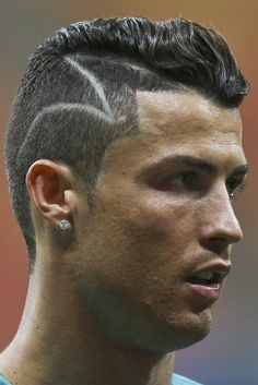 a close up of a person with a shaved haircut and piercings on his ear