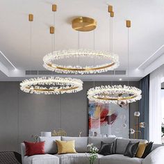 a living room filled with furniture and lots of lights hanging from the ceiling above it