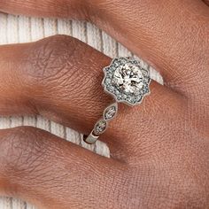 a woman's hand with a diamond ring on top of her finger and an engagement band